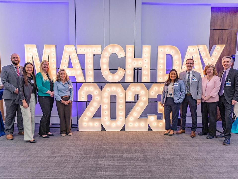 Families and students pose in front of the Match Day sign at Mayo Clinic in Florida