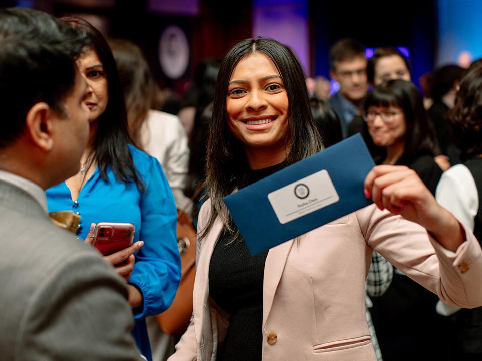 A med student shows off their blue envelope on Match Day at Mayo Clinic