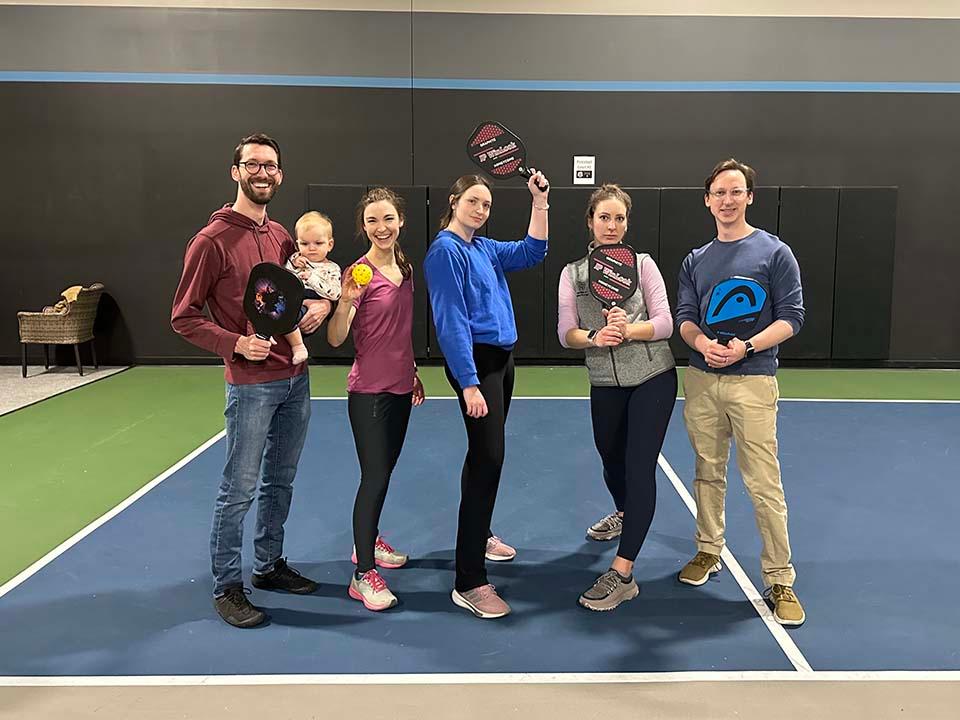 Several residents pose for the camera during a pickleball match.