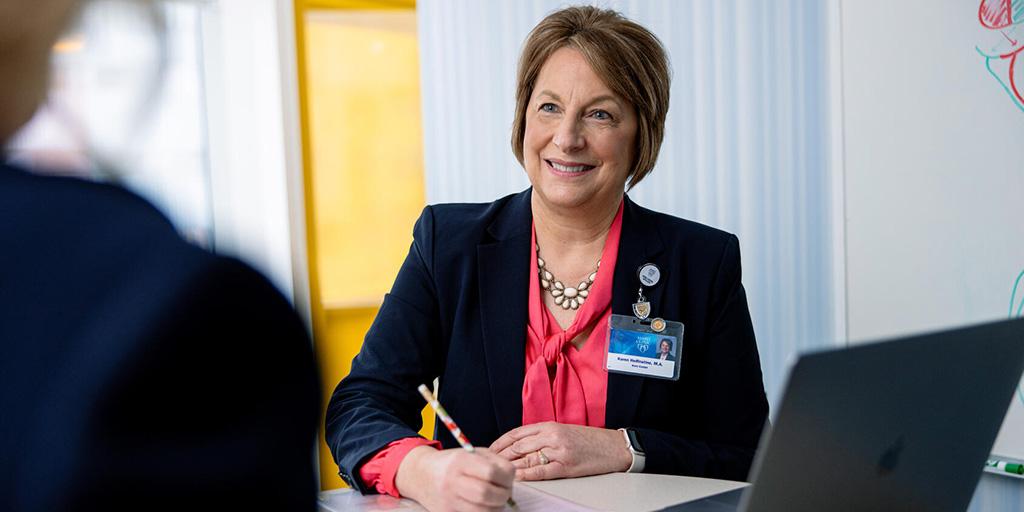 Karen Helfinstine, Mayo Clinic School of Health Sciences alumna, writes during a meeting