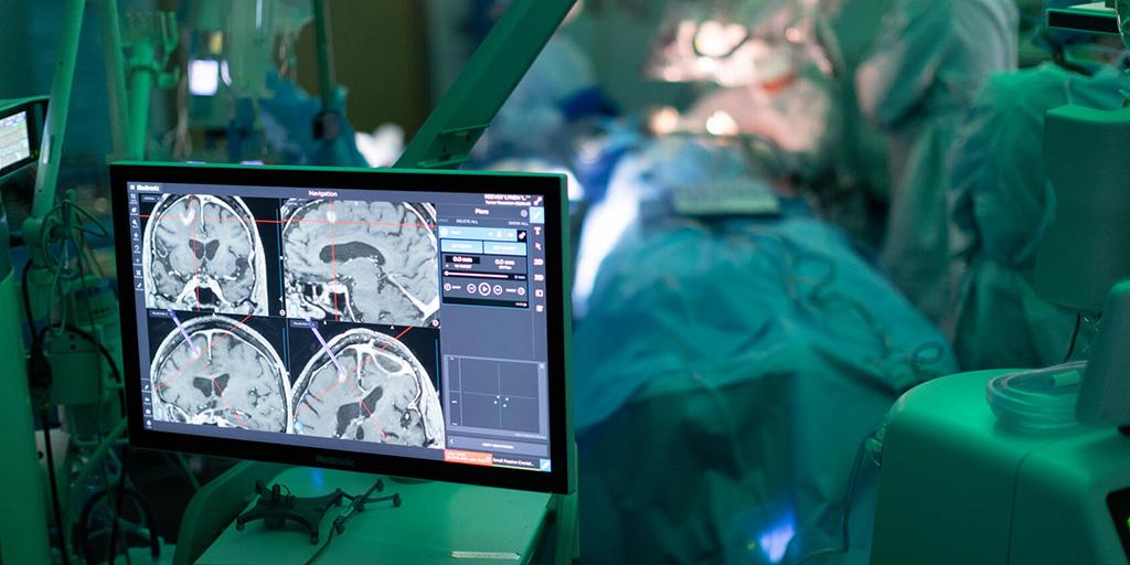 Neurosurgeon using surgical navigation system with cranial images displayed in the foreground