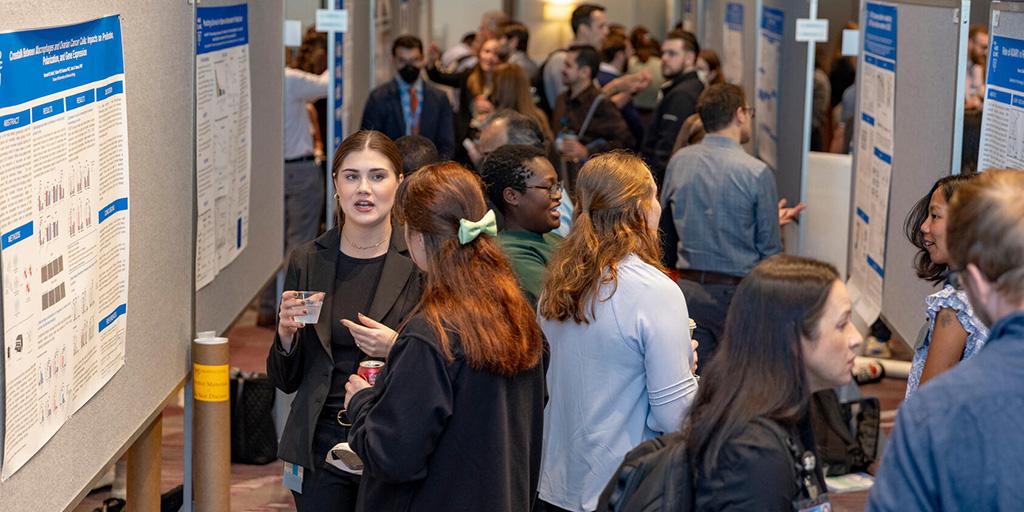 Crowds of people visit and view research posters at the 2025 Graduate School Research Symposium