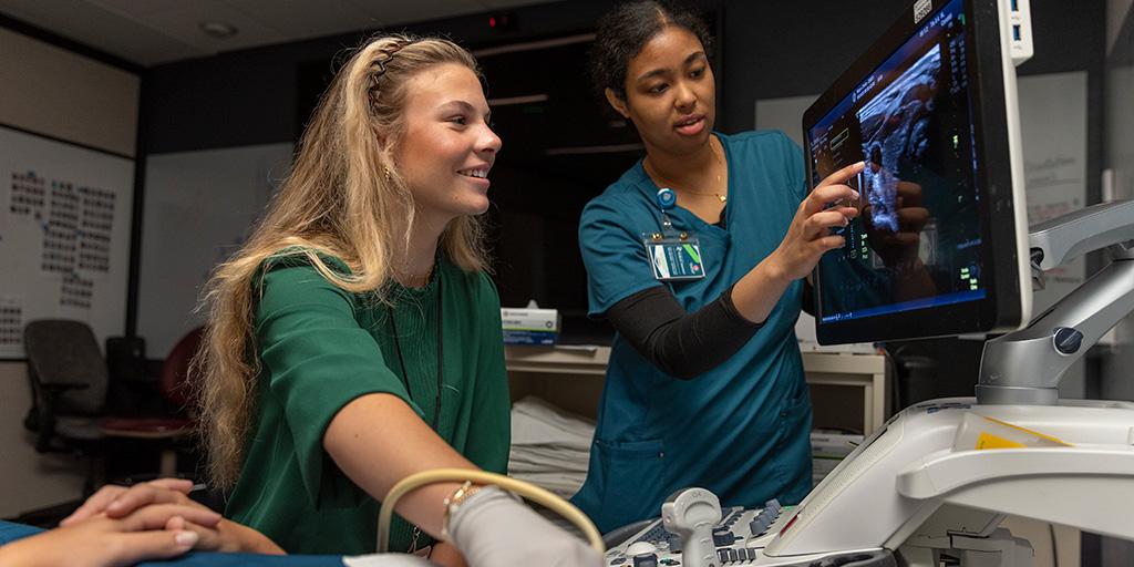 Two students in Mayo Clinic's Career Immersion Program learning how to perform an ultrasound on a patient