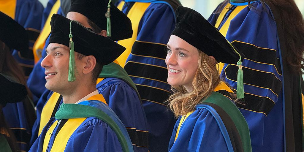 Two graduates in Mayo Clinic Graduate School of Biomedical Sciences wait for 2026 Commencement ceremonies to begin
