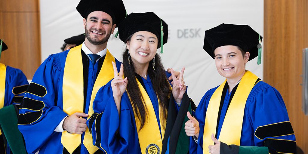A small group of Mayo Clinic graduates in Florida smile and pose for a photo at Commencement