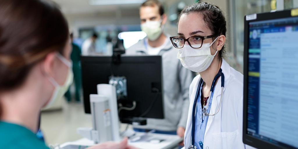 Jwan Naser, M.D., talks with a pharmacist about a patient's care in the hallway of the MICU in St Marys Hospital, Rochester, Minnesota.