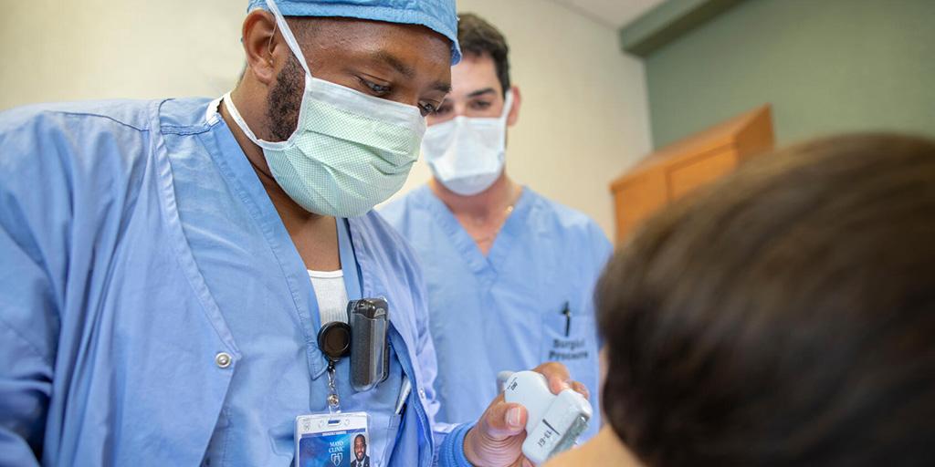 Anesthesiology resident Isaiah Coleman, M.D., prepares to do ultrasound of a patient's spine for epidural injection.