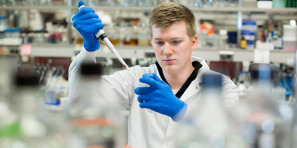 Research technician setting up samples using a pipette