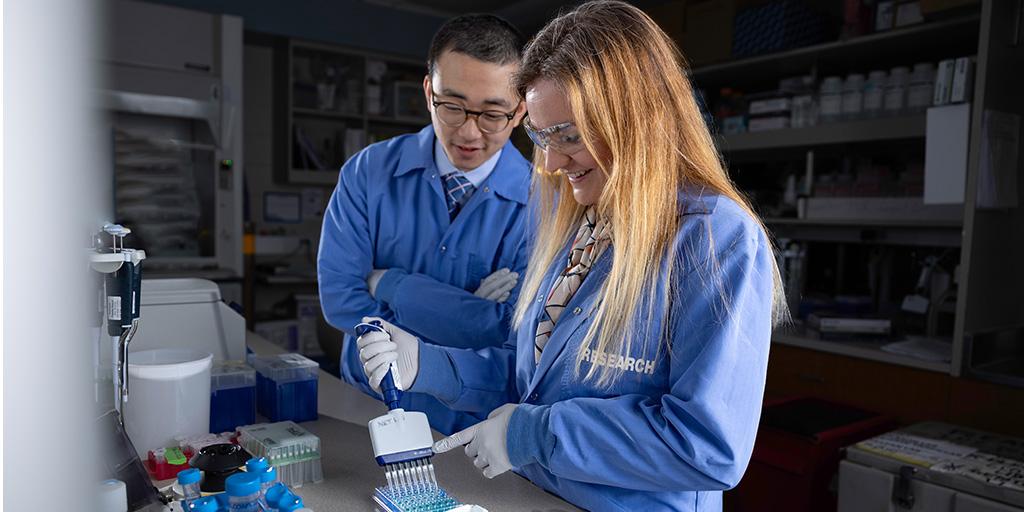Research Fellows, collaborating in the research lab using a multichannel pipette.