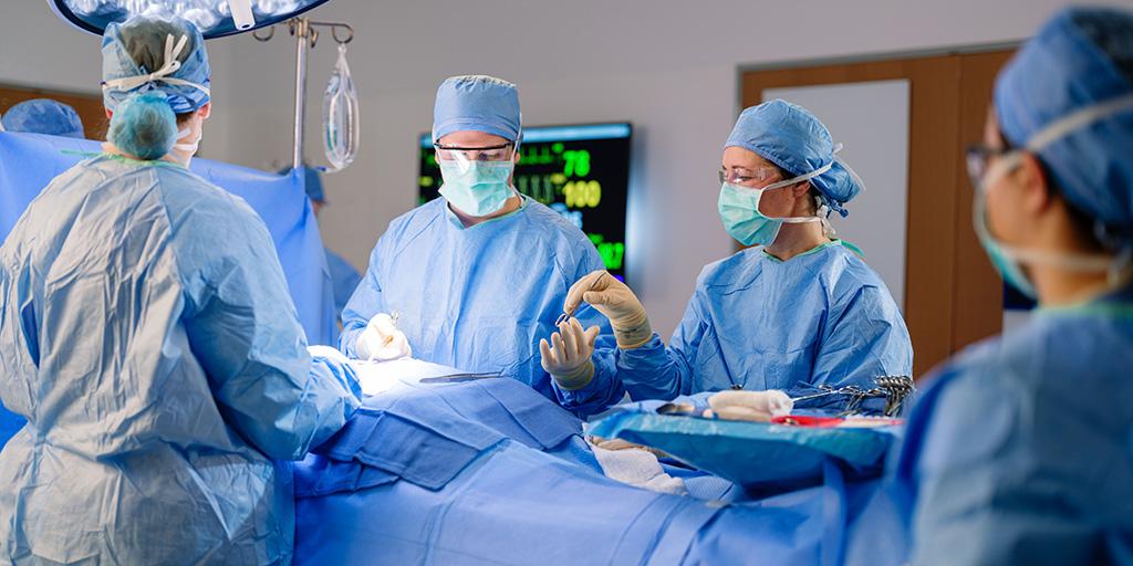 Surgical First Assistant hands an instrument to a surgeon in the operating room at Mayo Clinic