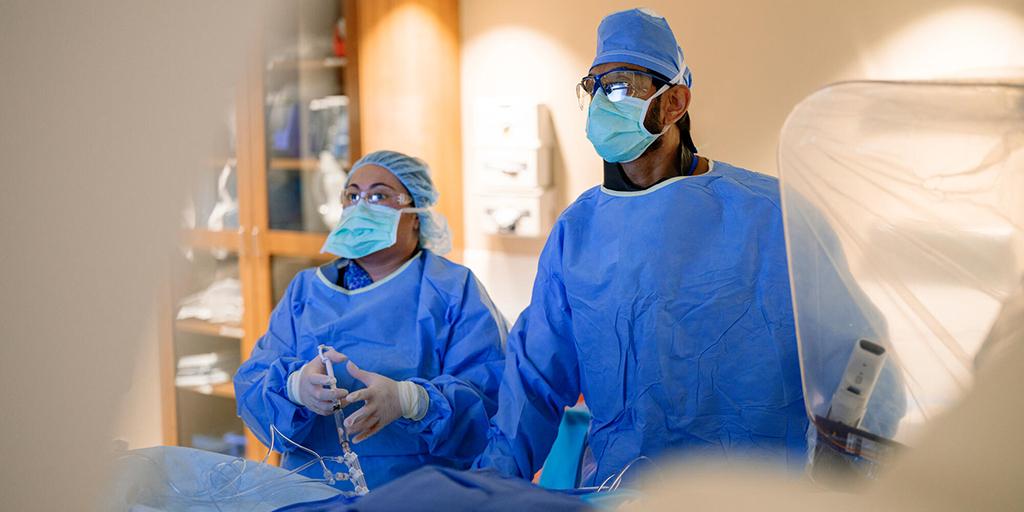 Ruth Campos, RCIS, Catheterization Laboratory (cath lab) technologist, and Ripudamanjit Singh, MD, Cardiology consultant, perform a procedure in the cath lab.