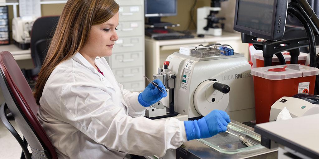 Histology technician preparing microscope slide