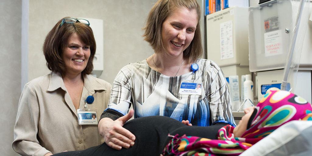 Two nurse midwives check in on a pregnant patient