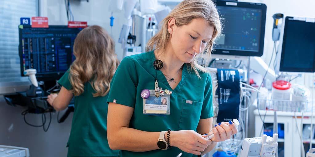 A nurse prepares an IV medication solution.