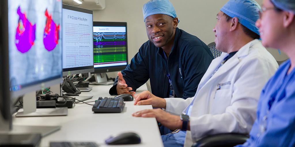 Doctors look at test results on a computer screen.