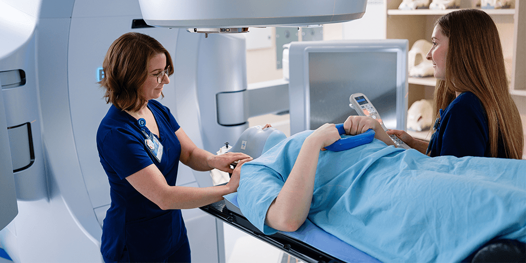 Radiation therapists working with a patient