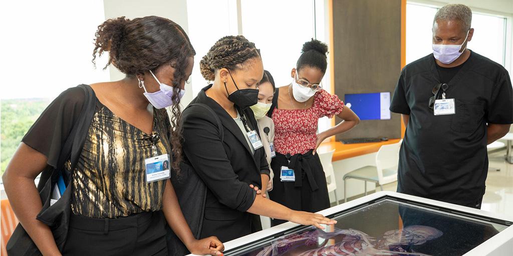 Interns use the Anatomage table during at the Simulation Center