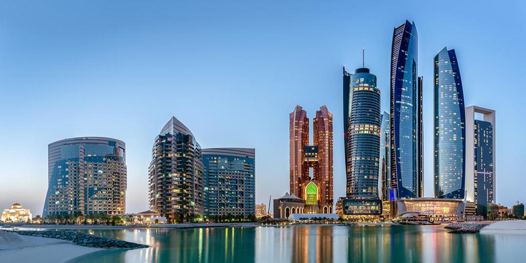 A view of skyscrapers in Abu Dhabi, from across water.
