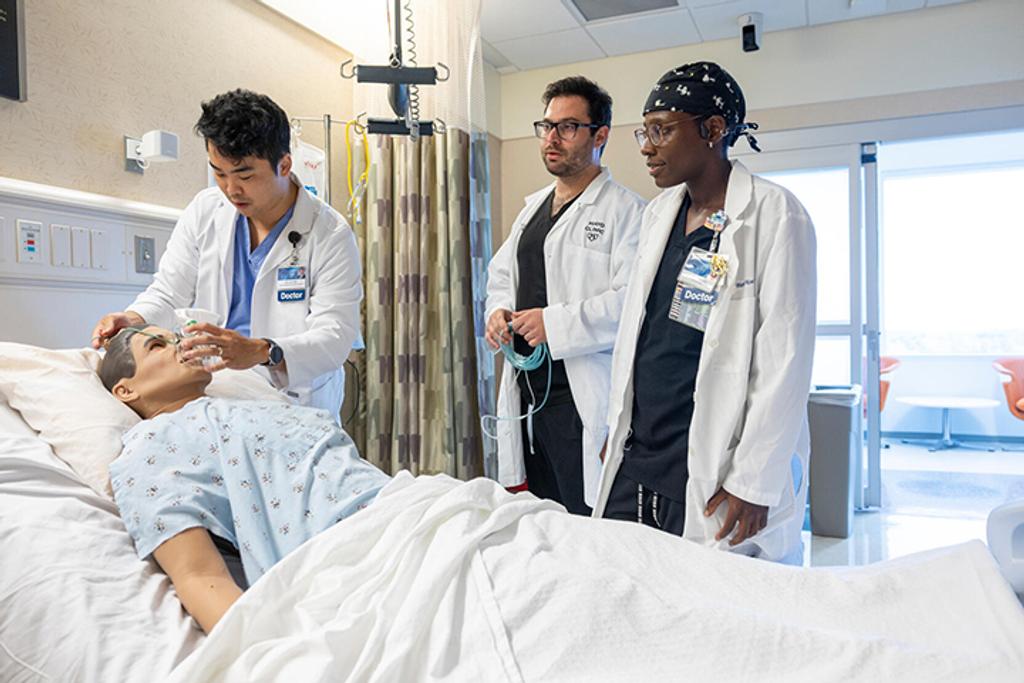A resident places a breathing mask on a medical mannequin during the Anesthesiology Resident simulation center workshop.