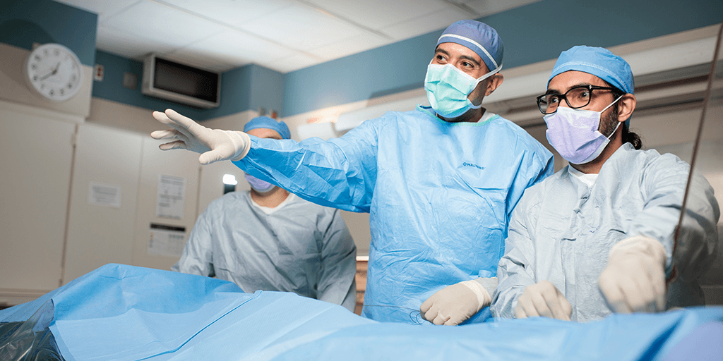 Atta Behfar, MD, PhD, Cardiology Consultant, mentoring Mohsin Abbas, MBBA, Cardiology Fellow, during a Cardiology Regenerative Medicine procedure in the operating room.