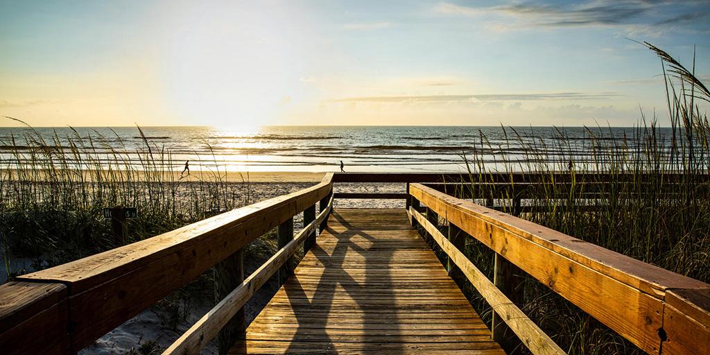Photo of wooden walkway leading to beach.