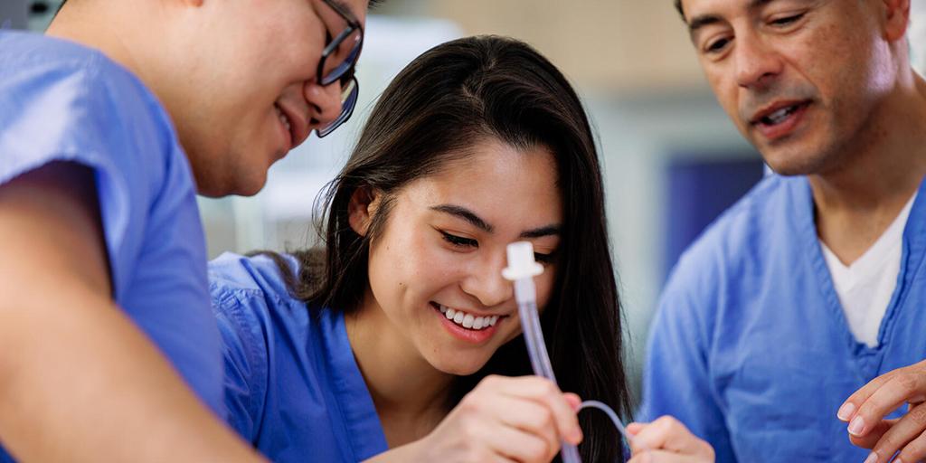 Three doctors perform a procedure in an operating room.