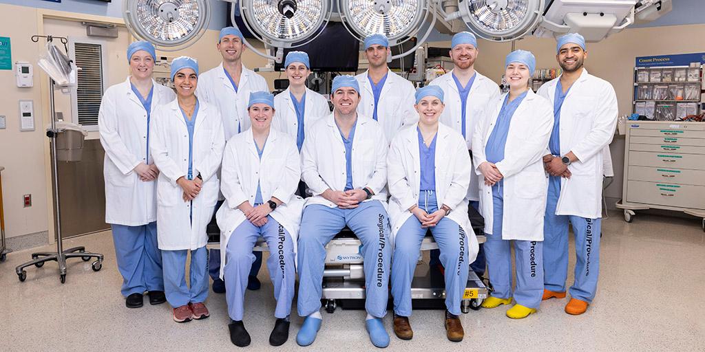 Alumni of the General Surgery program pose for a group photo inside the ER