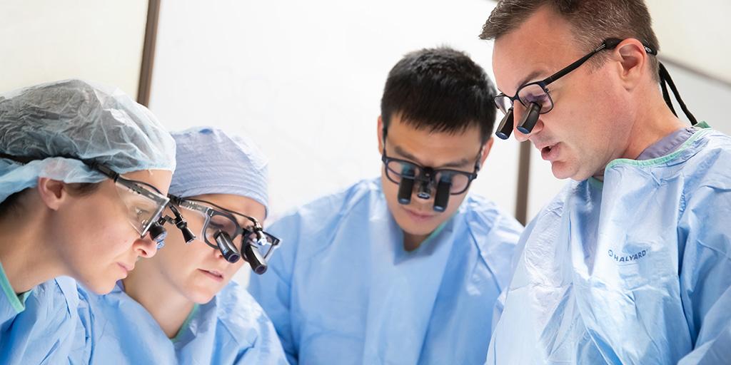 Four hand surgery fellows in operating suite