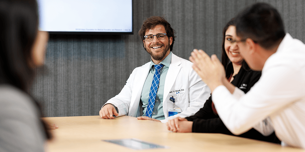 Fellow listening to colleagues in conference room