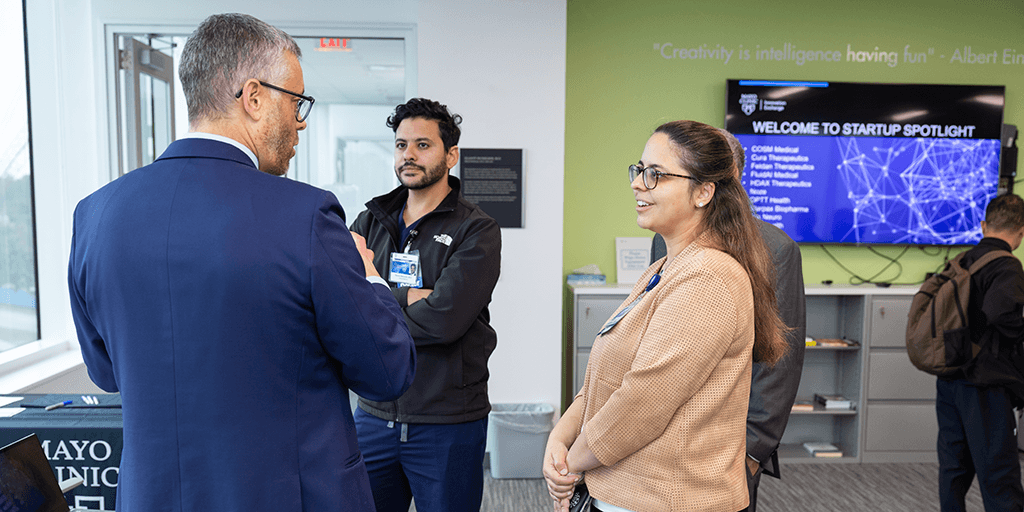 Students talking with instructor in classroom