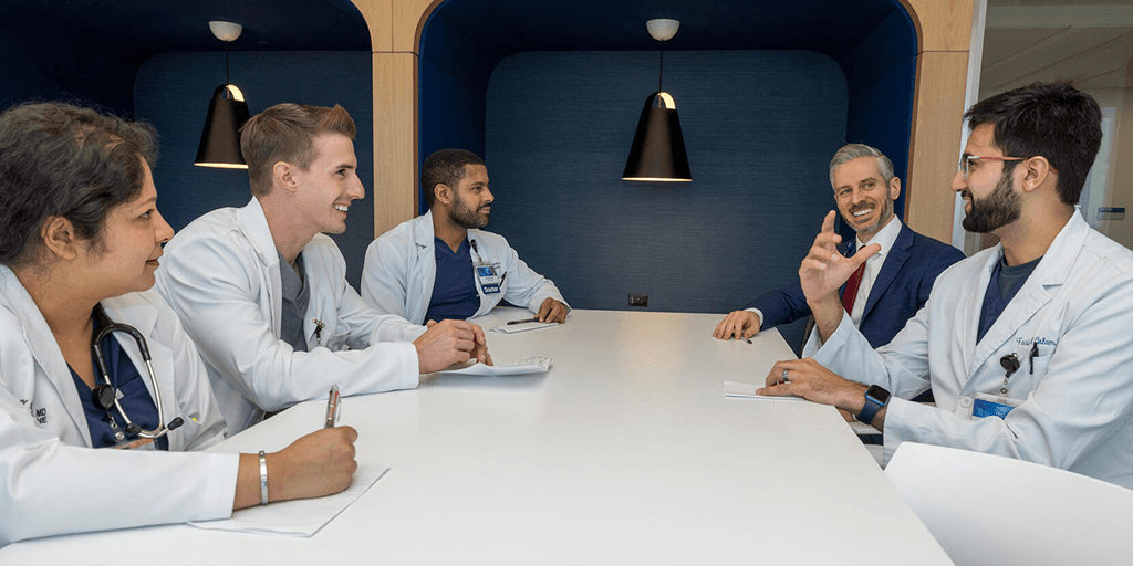 Residents and physician speaking in conference room
