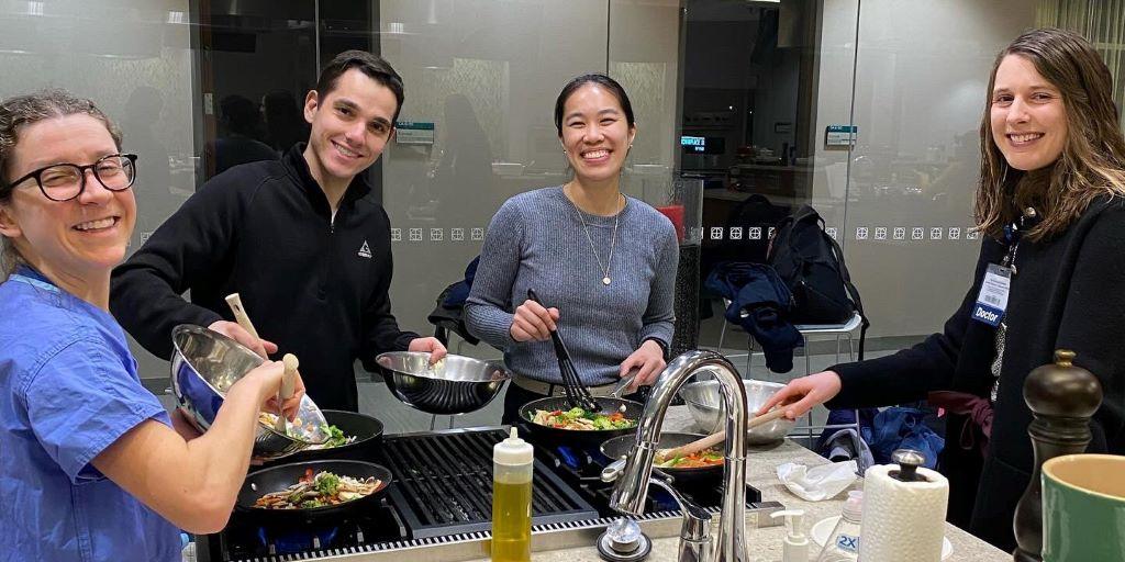 Drs. Finn, Cholack, Chen, and Schaible cooking a healthy meal at a residency-sponsored wellness event.