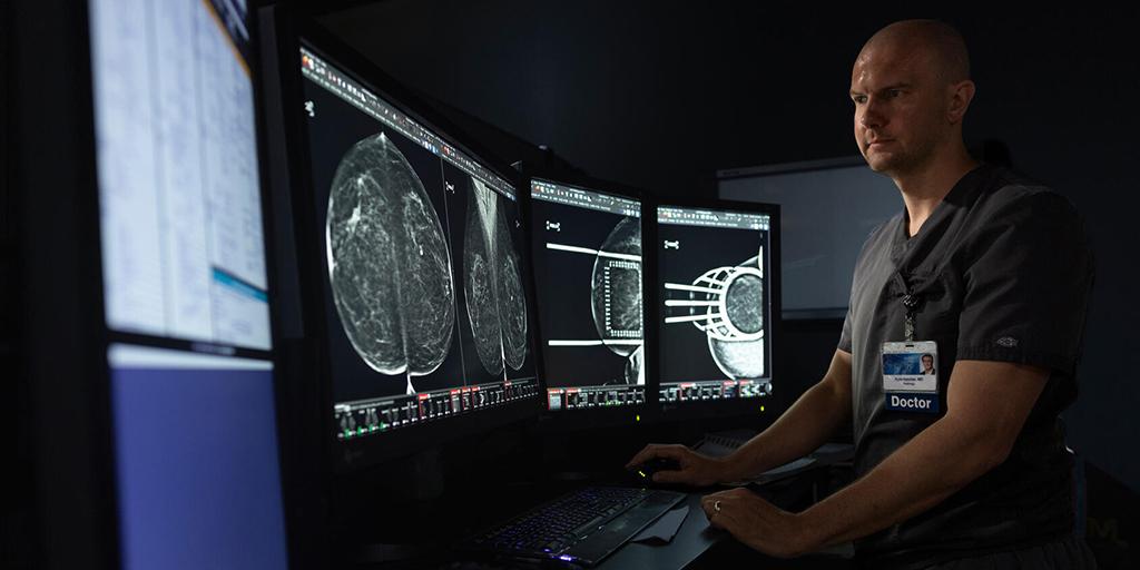 Description A diagnostic radiologist reviews medical imaging on a computer monitor.