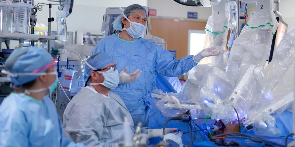 Members of the surgical team do various tasks, while Aaron Potretzke, MD, Surgical Urology consultant, observes during a robotic surgery..