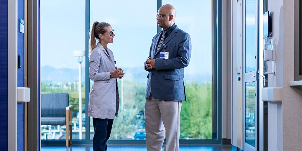 A fellow and faculty from the Neurohospitalist fellowship program conferring in a hallway