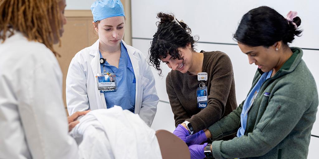 Residents perform an exam during a practice session.