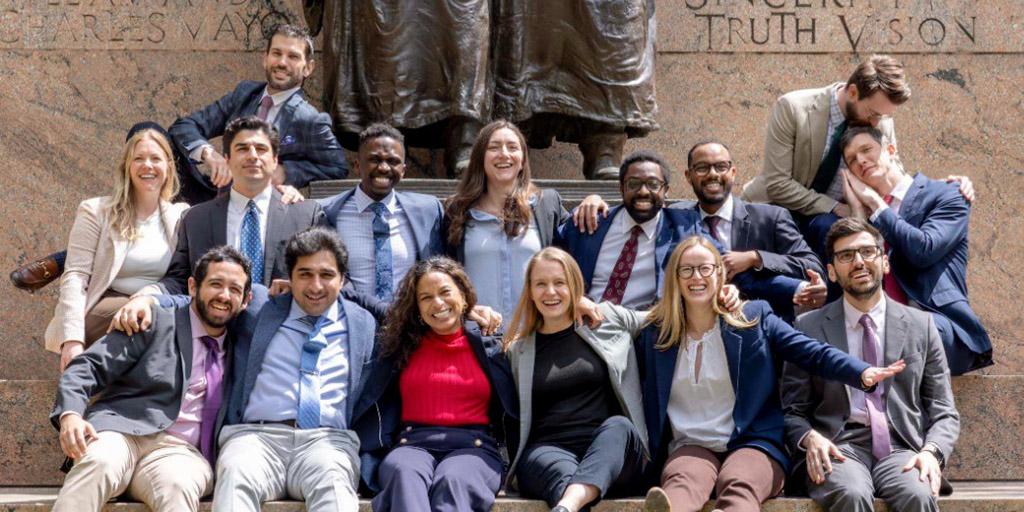 Residents pose for a group photo in front of a statute.