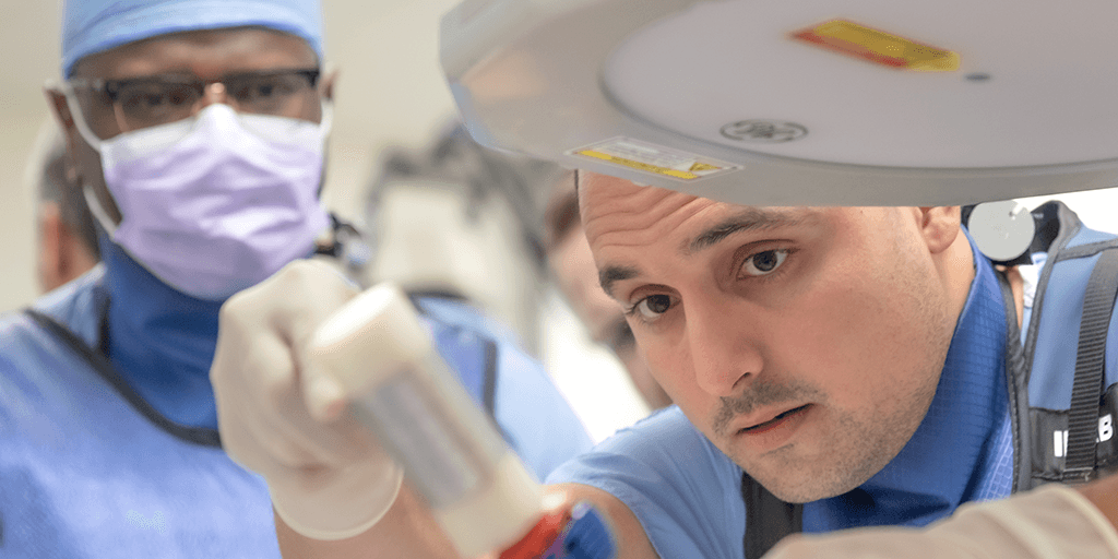 Two fellows in lab practicing a procedure