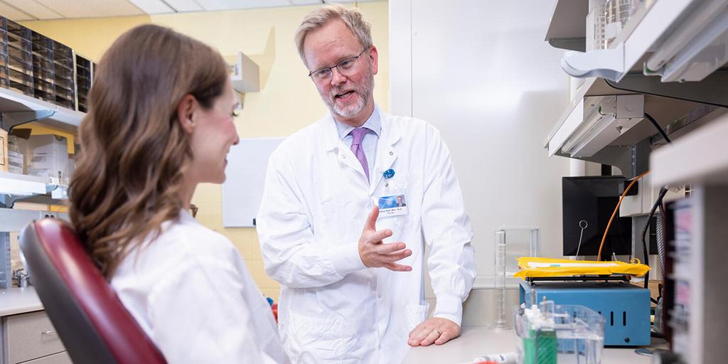 Two fellows from the Physician Scientist Program talking in a classroom