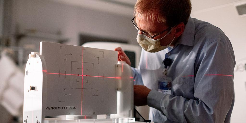A Mayo Clinic radiation oncology medical physicist inspects a piece of equipment.