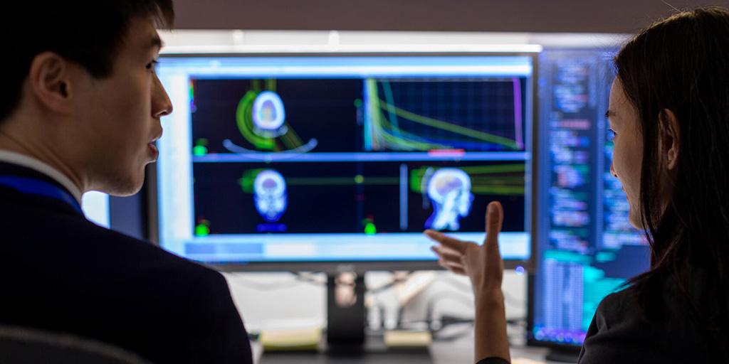 Cenji Yu, PhD, and Xueyan Tang, PhD, analyze images on a computer terminal.