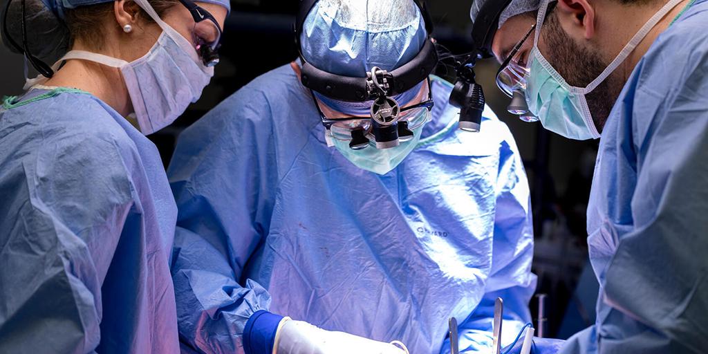 Katie Anderson, MD, Surgical Urology consultant, Maraika Robinson, MD, Urology resident, and Alexandr Pinkhasov, MD, MPH, Trauma and Genitourinary Reconstruction fellow, are all shown working in the sterile field during an operation.
