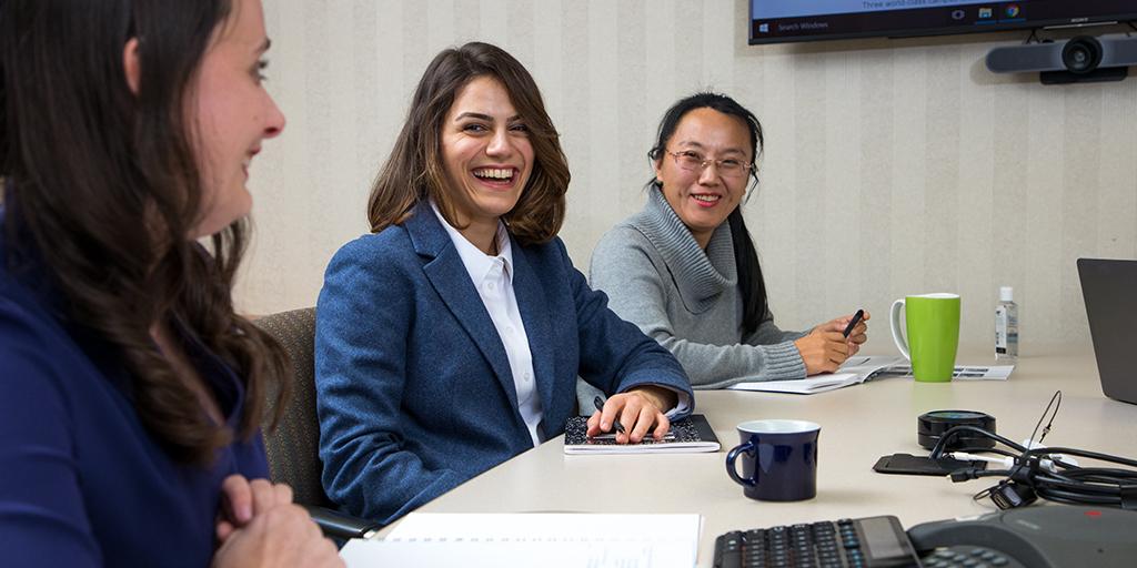 Mayo Clinic employees smiling and having a meeting.