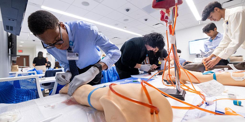 Students practice intravenous (IV) cannulation at an IV station during an experiential lab day of the Mayo Clinic Career Advancement, Research, and Education Summer (CARES) Program for high school students.
