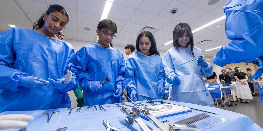 Students examine surgical instruments during an experiential lab day of the Mayo Clinic Career Advancement, Research, and Education Summer (CARES) Program for high school students.