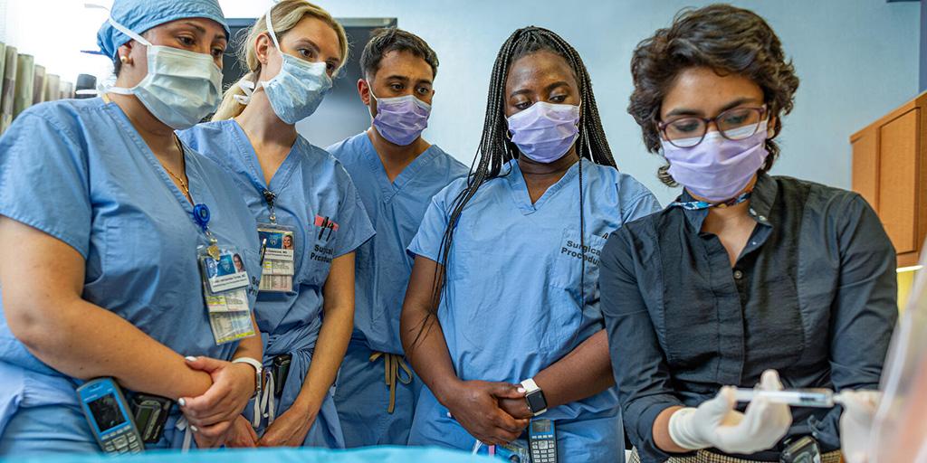 Residents in anesthesiology watch a faculty member complete a procedure
