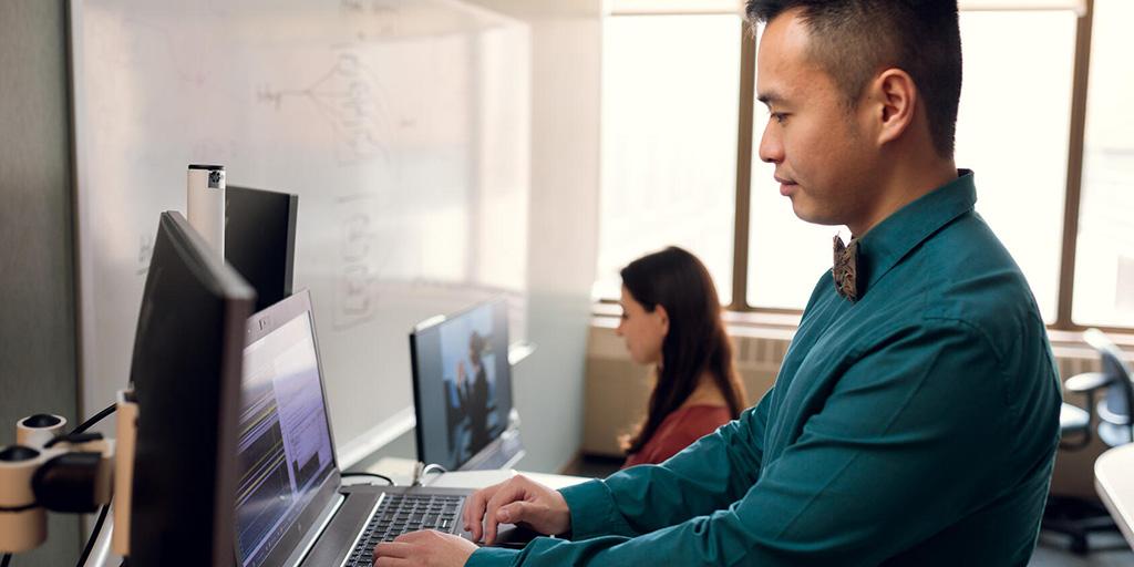 A Mayo Clinic researcher works on a computer next to a colleague