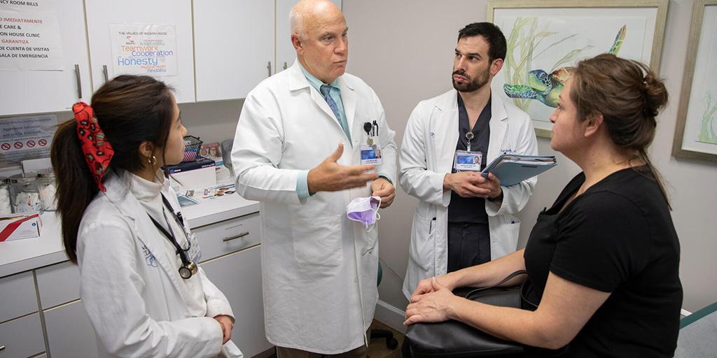 Medical students and a doctor meet with an unhoused client of Mission House during her appointment.