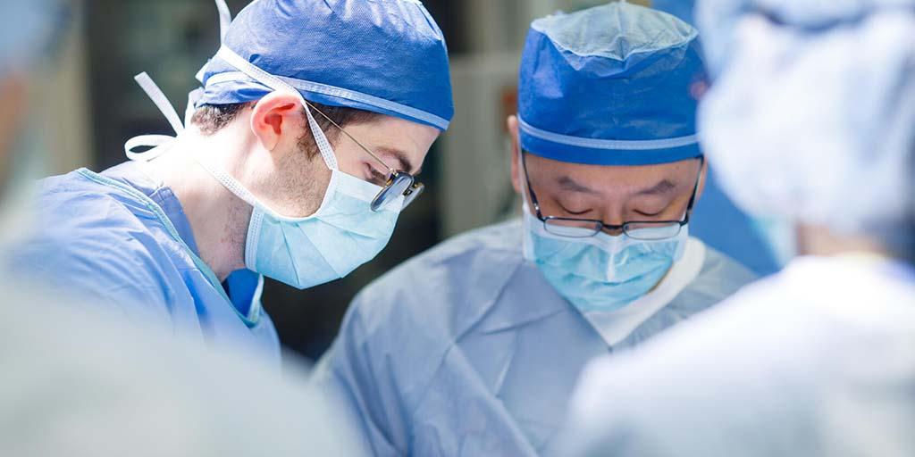 Dr. Lee performing surgery with a resident.