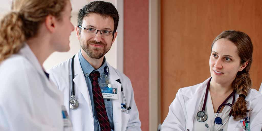 Three residents talking together at the reception desk in the hospital